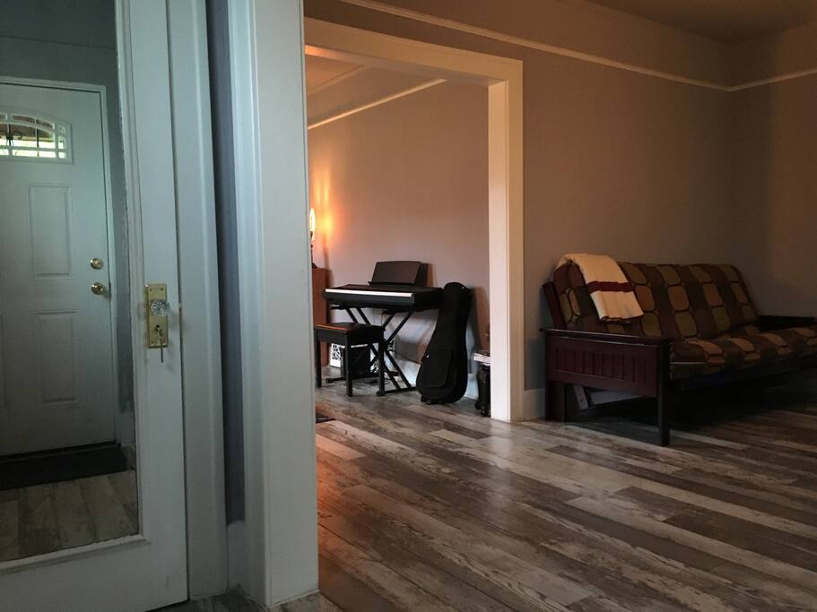 As you walk into our home, there is a large coat closet with a full door mirror. To the right is dining room and further back you'll find the living room. The futon and piano are temporary as we get situated and wait to move to the upstairs unit. The futon will be gone and the piano replaced with a televison.
