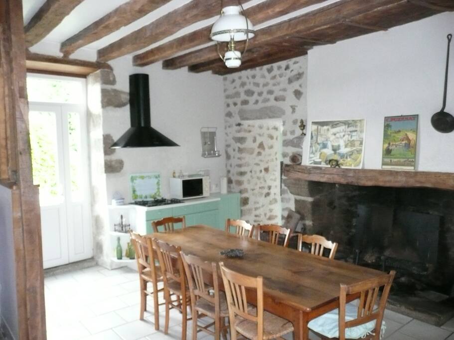 Grande cuisine , pièce de vie avec cheminée et arrière cuisine toute équipée .Deux portes fenêtres apportant beaucoup de luminosité et donnant d’un côté sur le jardin et l’autre sur la terrasse