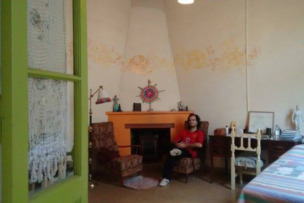 Es la sala de estar - living, amplio y luminoso. Tiene estufa, dos sillones y un escritorio.