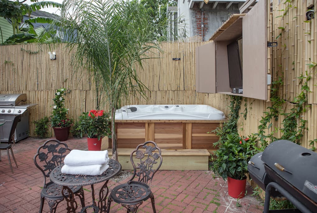 Private backyard with outdoor jacuzzi, BBQ pit, and tables & chairs.
