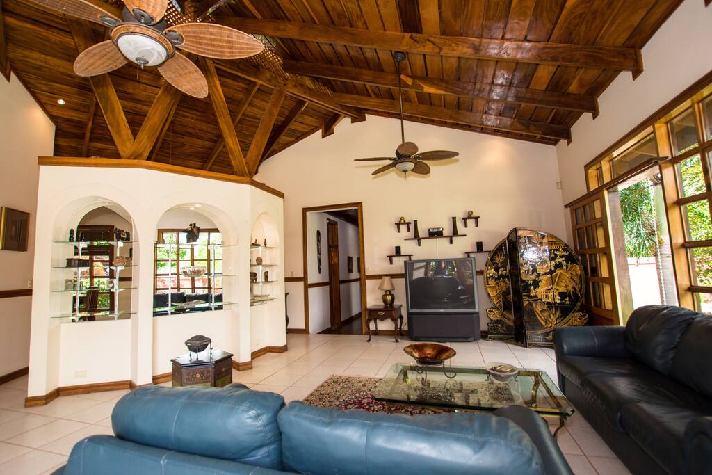 Living room & foyer with mirrored privacy wall, Vaulted ceilings and decorative fans keep the place cool on the hottest days.