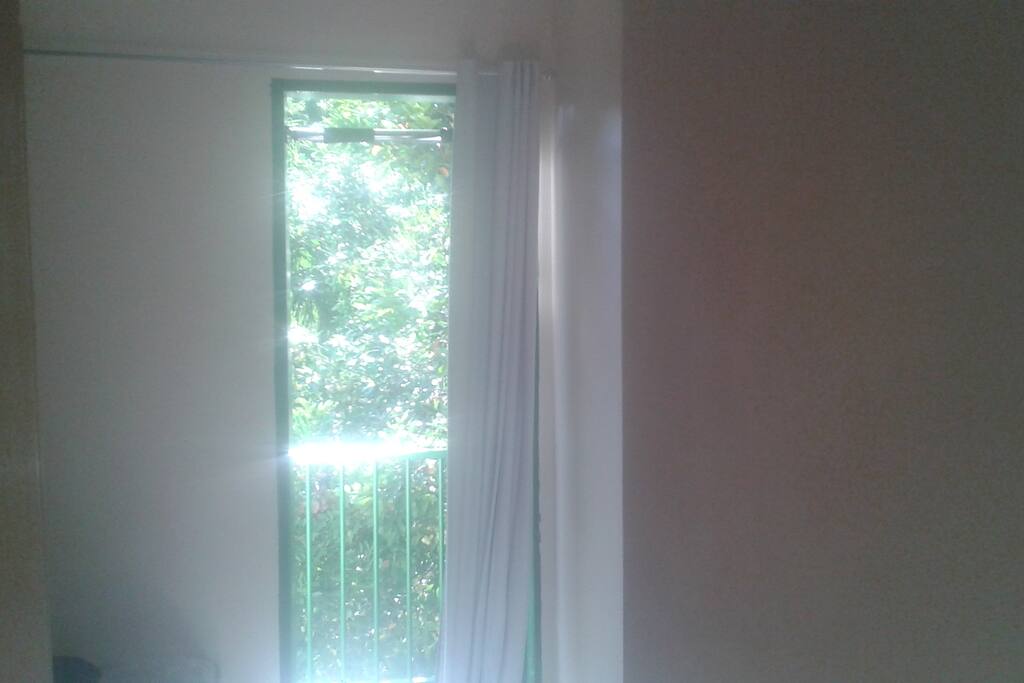Porta do quarto do hóspede que dá acesso à varanda e garante a boa ventilação do quarto (com cortina "black out", para quem quiser dormir até mais tarde).