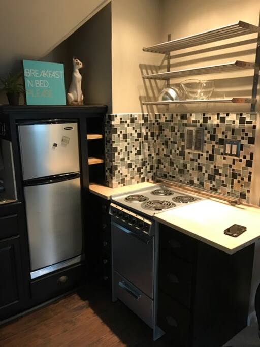 Kitchen with small fridge, stove and microwave