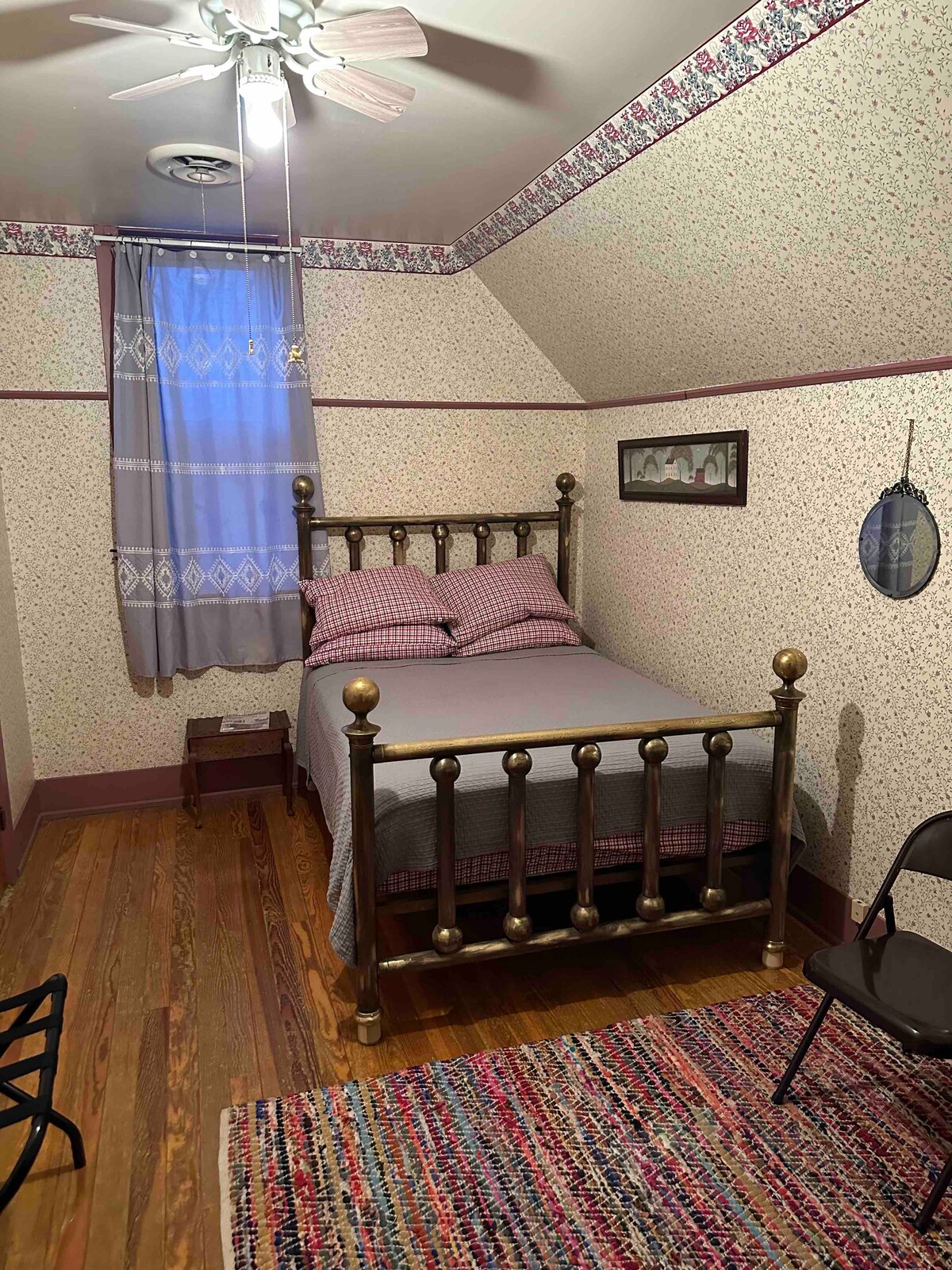 Спалня за гости на горния етаж с месингово легло в пълен размер.