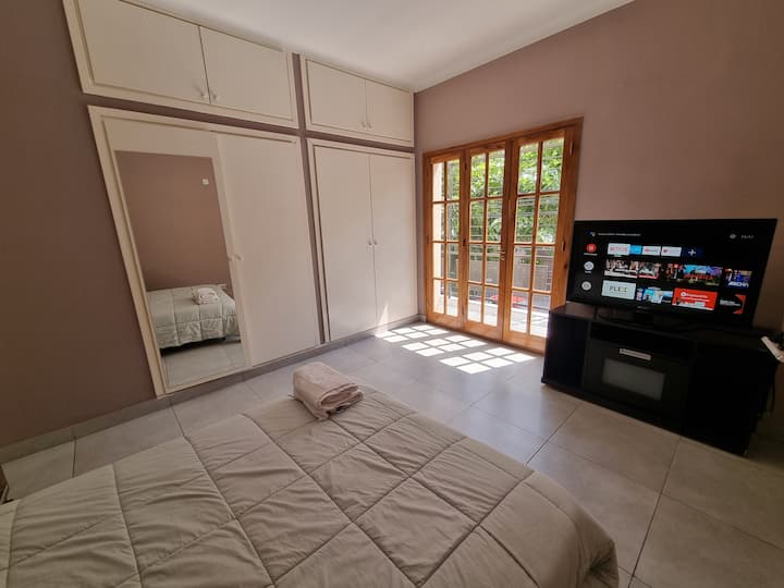 غرفة تضم سريرًا لشخصين وتلفزيون وإمكانية الدخول إلى الشرفة