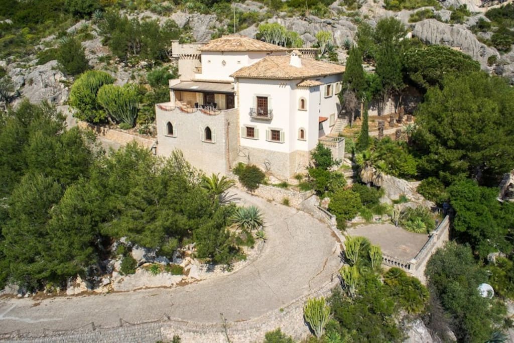 wrought iron gate opening on a winding private road leading to the inner courtyard