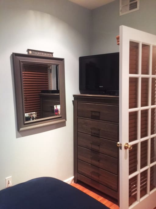 Dresser, mirror and television at the foot of the bed