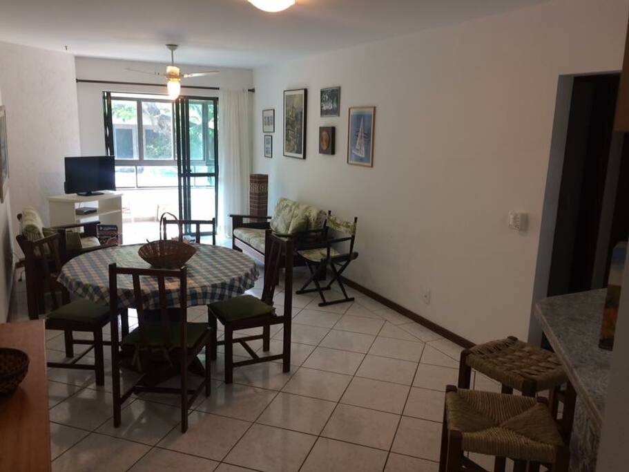 Sala de estar com TV e ventilador de teto.