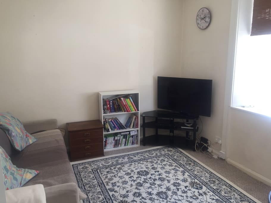 Lovely bright living room with sofa, dining table in the corner (shown in other pics), and a big bay window looking out onto the street. Sofa will be equipped with comfy bedding when a 5th person is staying and sofa pillows are easily rearranged for a comfortable stay.