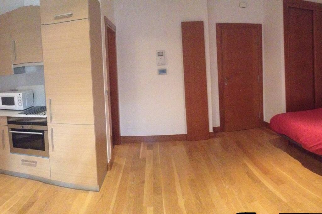 Estudio de una sola estancia con cocina y cama de matrimonio.