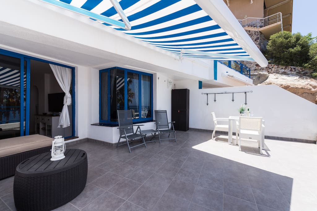 Large terrace with sofa group, sun beds and dining table.