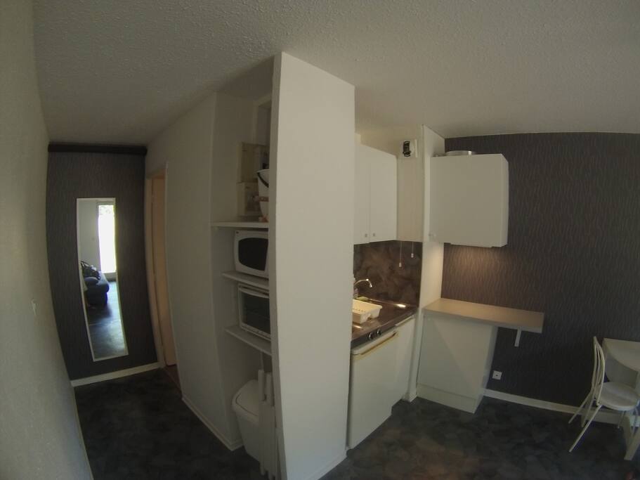 VUE DU COIN CUISINE EQUIPEE AVEC COULOIR MENANT A LA SALLE DE BAIN