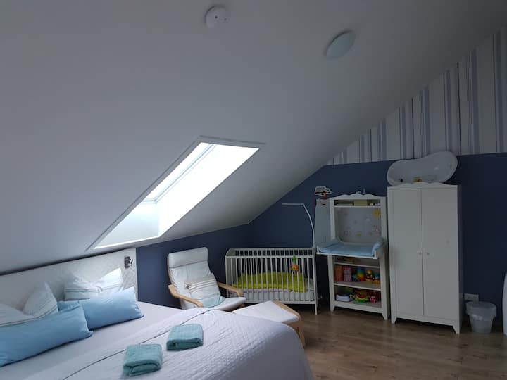 Красива семейна спалня с пълно оборудване за бебето и малките деца