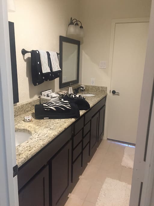 Bathroom attached to blue bedroom. Full tub and shower.