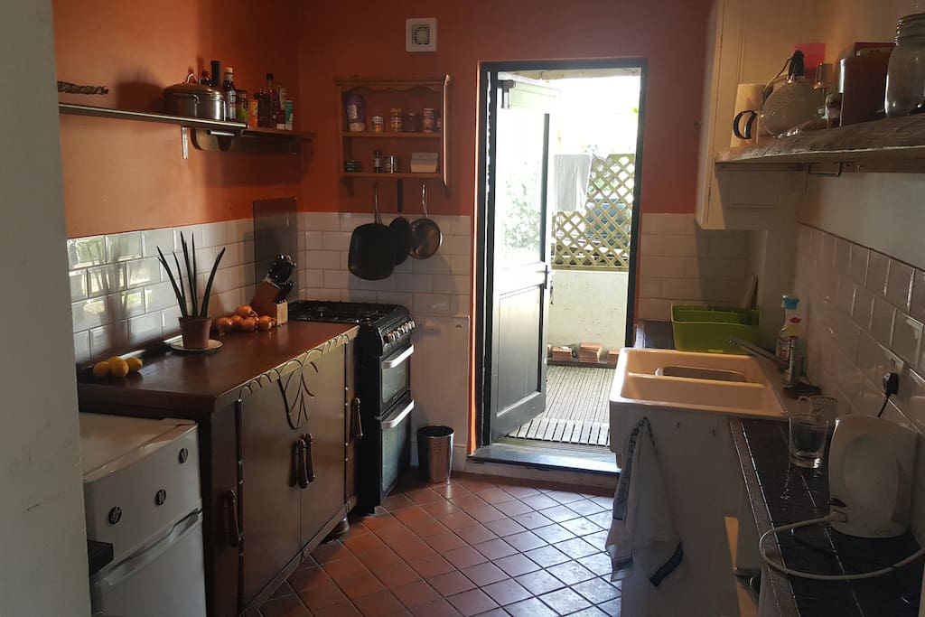 The kitchen from the living room door towards the backdoor. Double sink. Fridge/Freezer. Washing machine. Gas hob/oven.