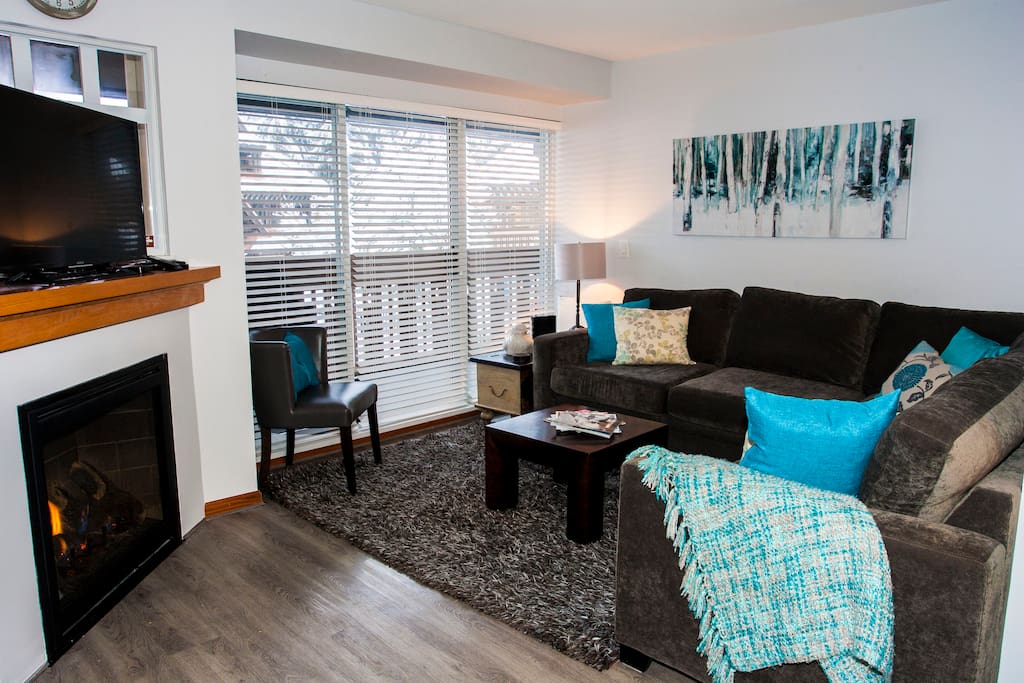 The living room is comfy and bright with a full size sectional with pull out bed and views of the pool and mountains from the deck.