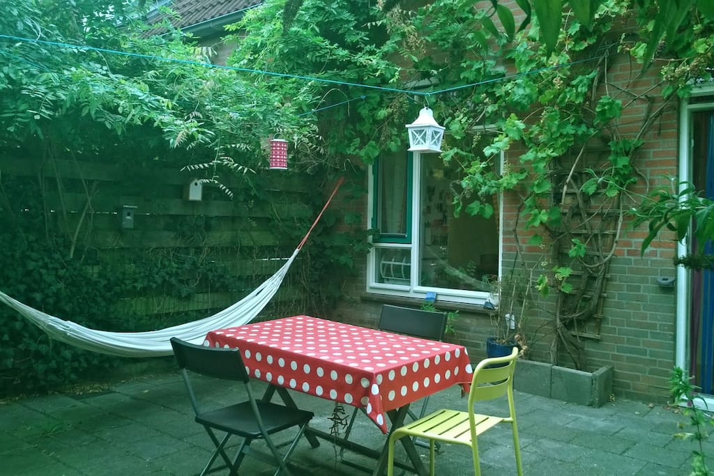 Cozy and sunny patio with green garden and bike storage