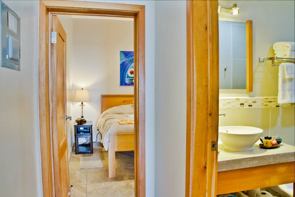 Hallway from Bedroom past bathroom and to kitchen, living and dining rooms, then veranda, pool and beach.