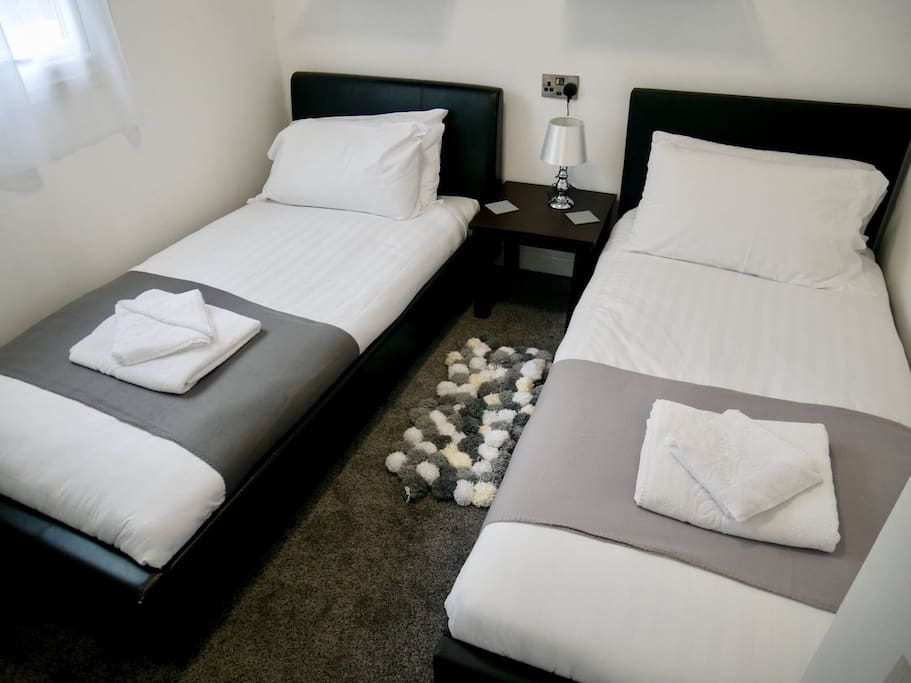 Bedroom 2, two faux leather single beds, wall mounted panel heater
