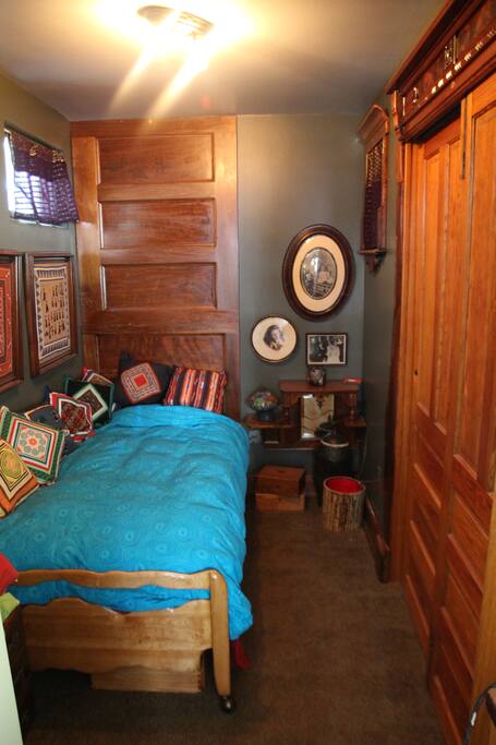 This listing--First floor bedroom with twin bed. It is small but cozy. The closet is filled with the boiler and hot water tank which make occasional noise. The head board is a walnut organ case from a local church and the trim is a repurposed walnut Victorian bed. The sliding Victorian wooden doors do not have a lock.