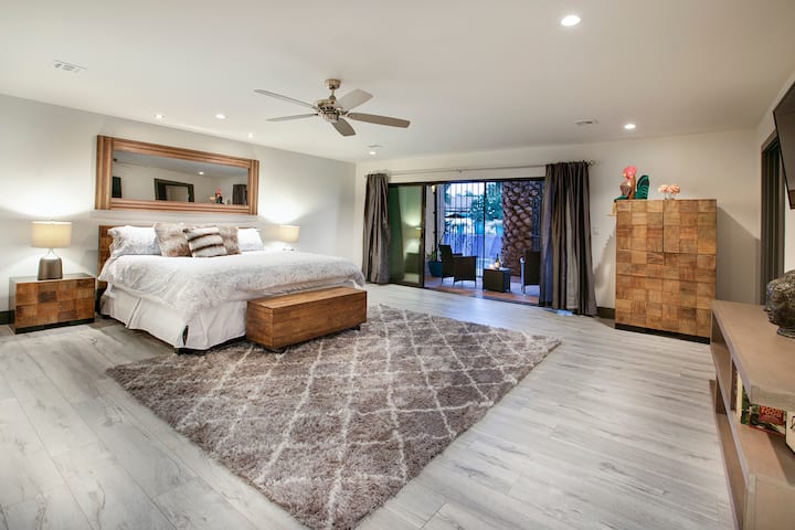 PRIMARY SUITE BEDROOM WITH KING BED AND PRIVATE BALCONY TO THE POOL