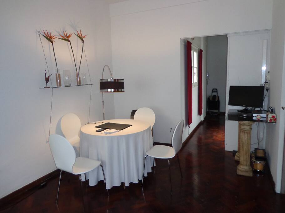 Mesa con cuatro sillas y una Lampara curva que le da mas calidez a la mesa ademas cuenta con un LED TV con servicio de cable