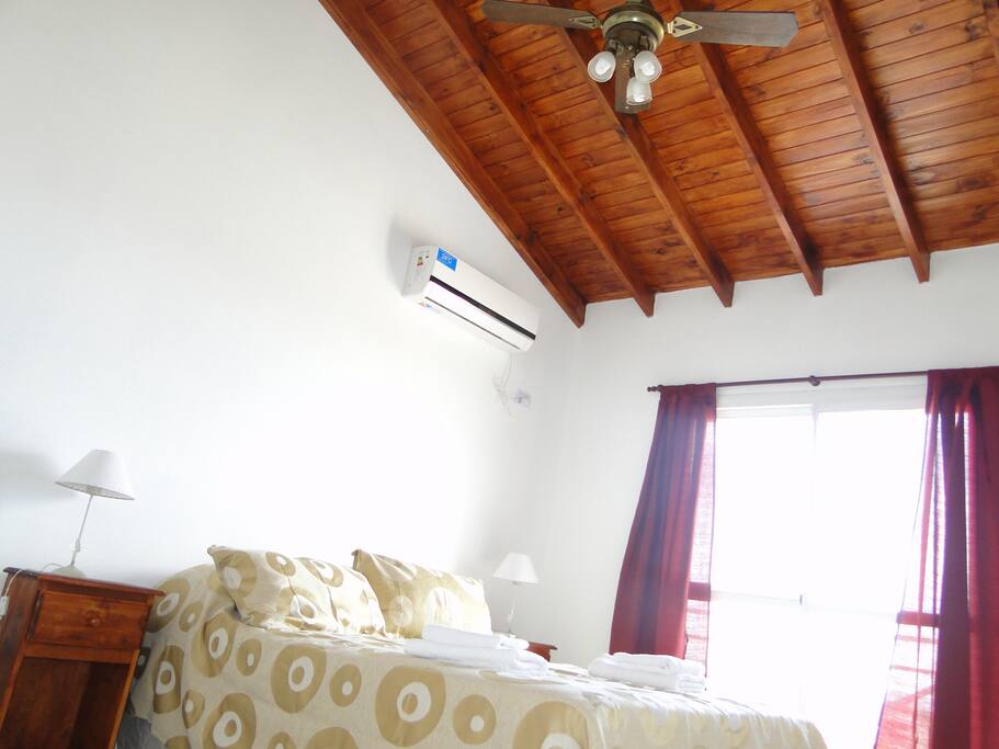 UCHAIMAÑE- habitación matrimonial, cama somier -Aire acondicionado y ventilador de techo. Cortinas y persianas- Techo de madera- Mesitas de luz- Placard- Balcón