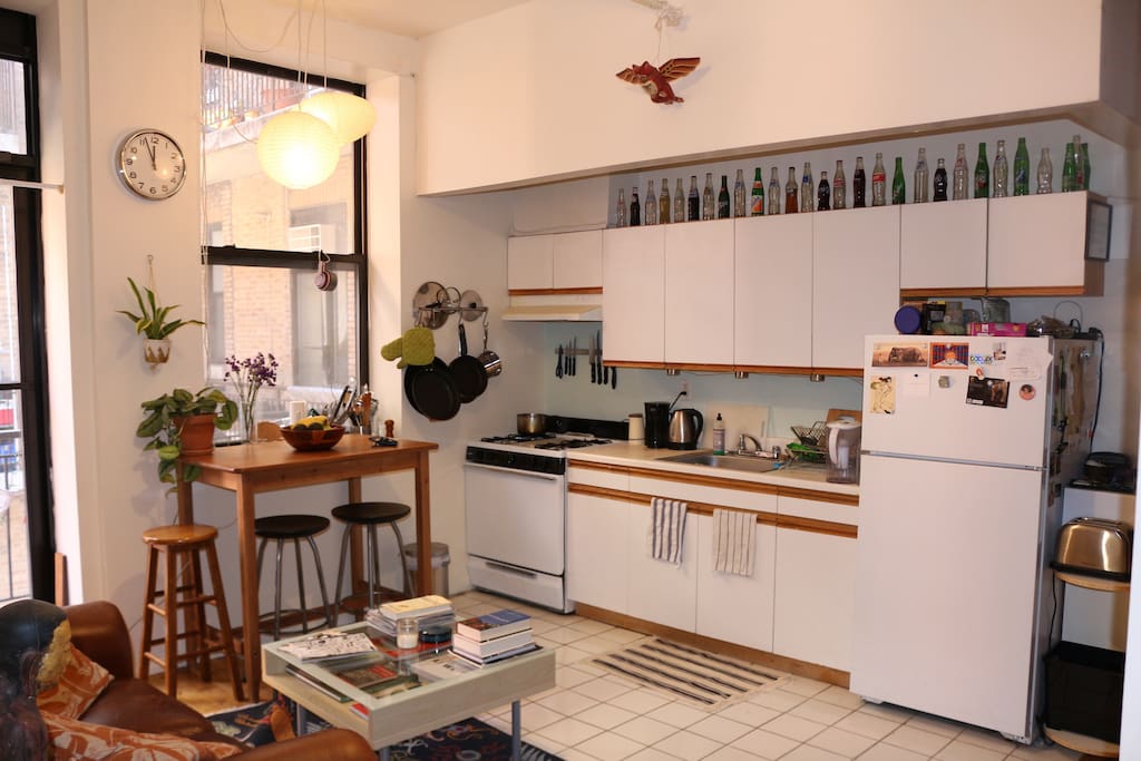 The bright and airy kitchen area is stocked with appliances and a high table perfect for meals and drinks.