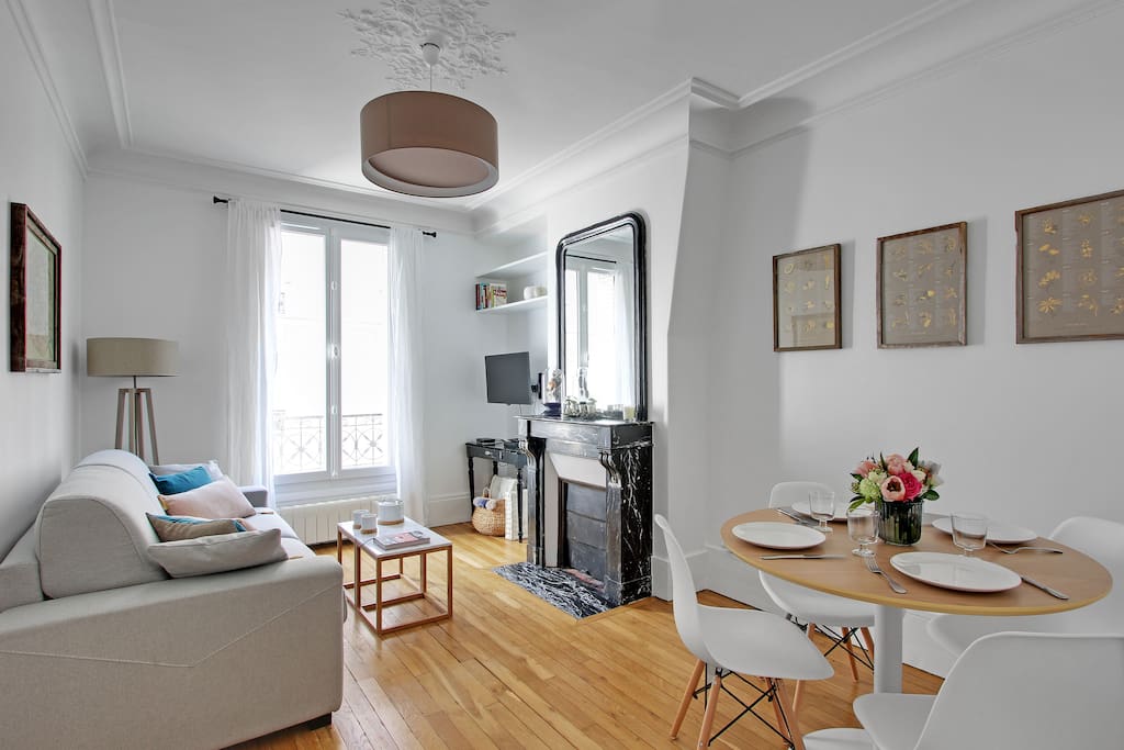 The comfortable living room and dining room are filled with natural light at your Paris vacation apartment. The sofa can convert to a bed should you wish to have separate sleeping areas.