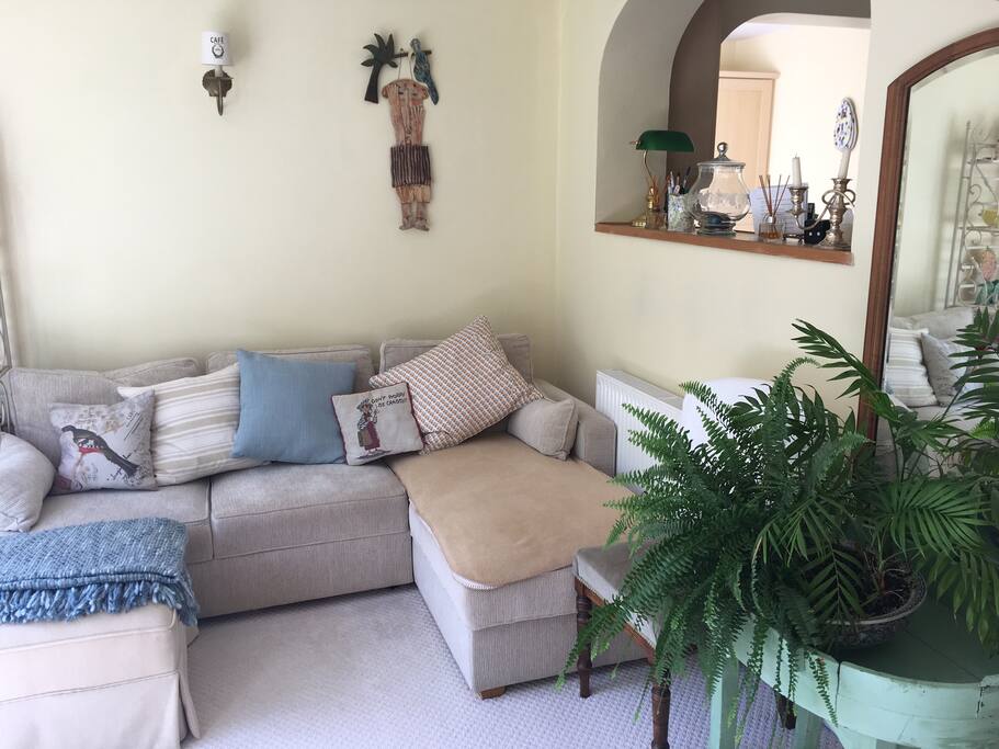 Relaxing sun lounge, with glazed double doors leading to garden.