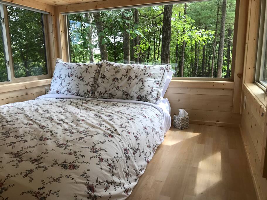Lofted bedroom with three walls of windows, and amazing views of the woods and creek below