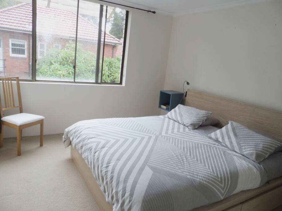 Main bedroom with a comfortable king size bed and a renovated bathroom with shower.