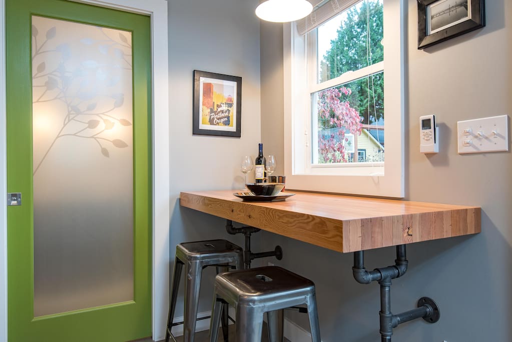 Salvaged wood slab bar with vintage pipe brackets, great spot to sip morning coffee, work on your laptop or just hang out. Frosted glass pocket door leads back to secluded bathroom.