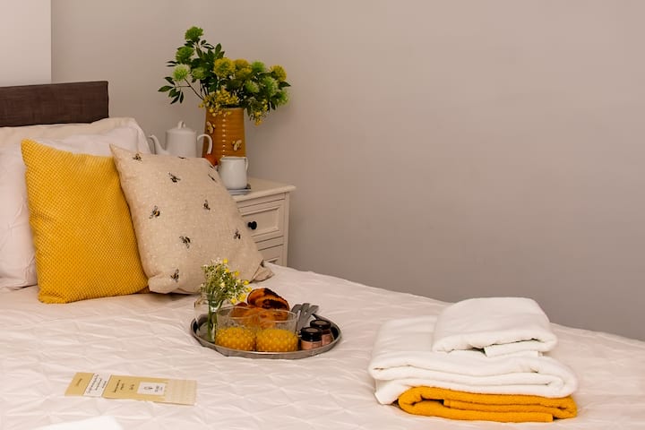 Dormitorio encantador con pasteles frescos, iluminación cálida y obras de arte: la comodidad te espera