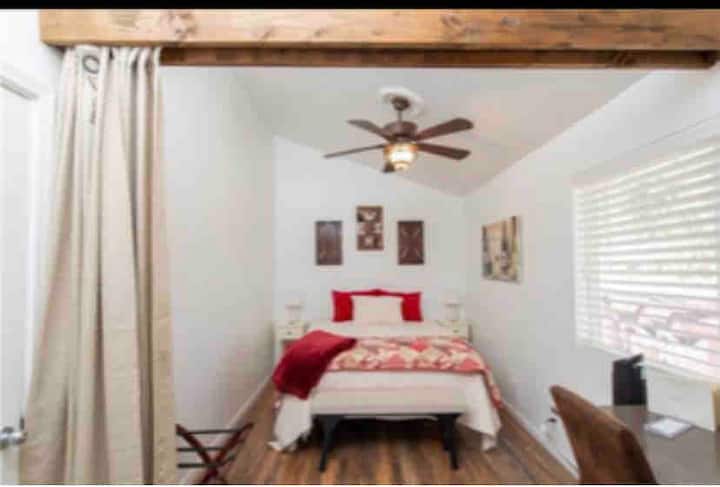 Საძინებლის ქვედა ნაწილი დიდი საწოლითა და კონფიდენციალურობის ფარდით. 