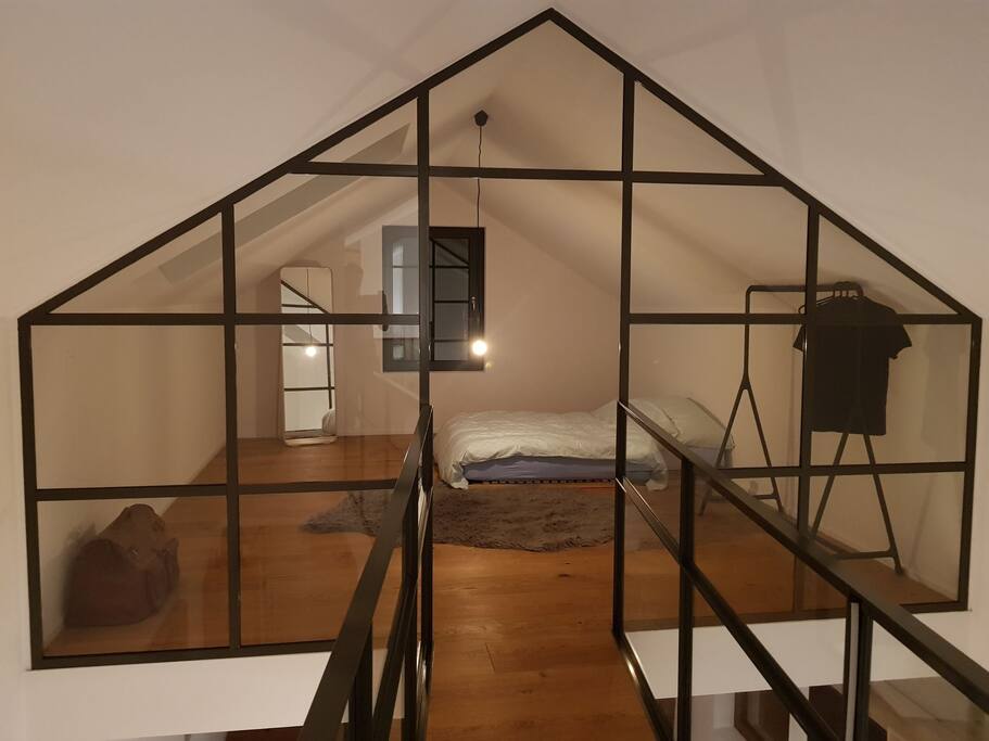 chambre de 20m2 séparée du reste de l'appartement par une verrière et une petite passerelle