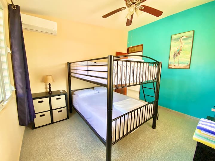 Tercer dormitorio con literas dobles, aire acondicionado y vistas a la piscina/al mar desde las ventanas. Ideal para que los niños o jóvenes lo compartan. Capacidad para 4 huéspedes. 