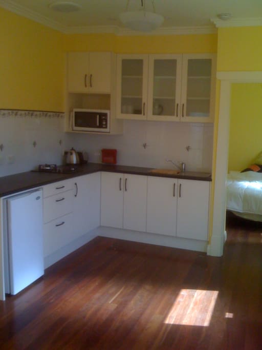 Kitchen area with ample storage, and bench top, cooktop, fridge, microwave,sink , toaster, kettle and expresso coffee pod machine