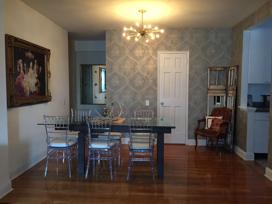 Wallpapered dining room with custom chandelier ,original oil painting and antique mirror. Beautiful table-seating for 8 (table extends and extra seats are in closet)