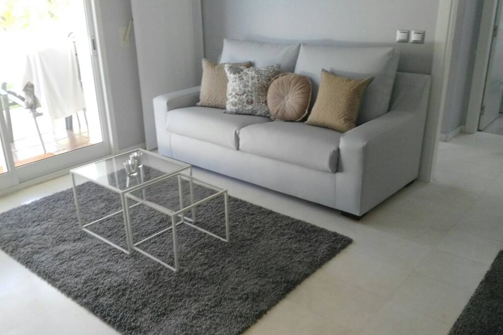 Sala de estar con TV de 49" y sofá cama