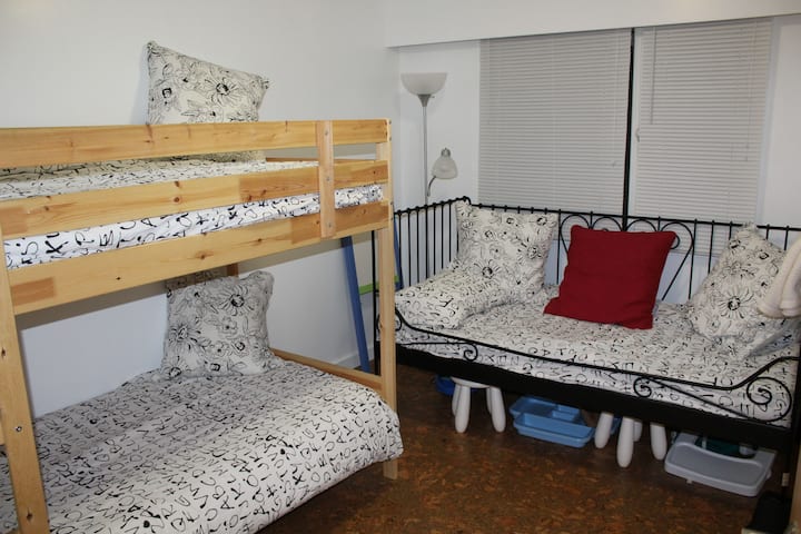 Spálňa pre deti s oddelenými poschodovými posteľami a dvojlôžkom.