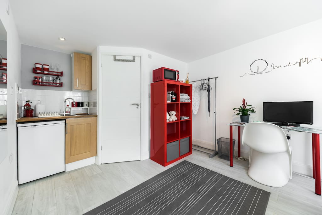 Studio room, desk, TV, clothes rail, shelving, kitchen area