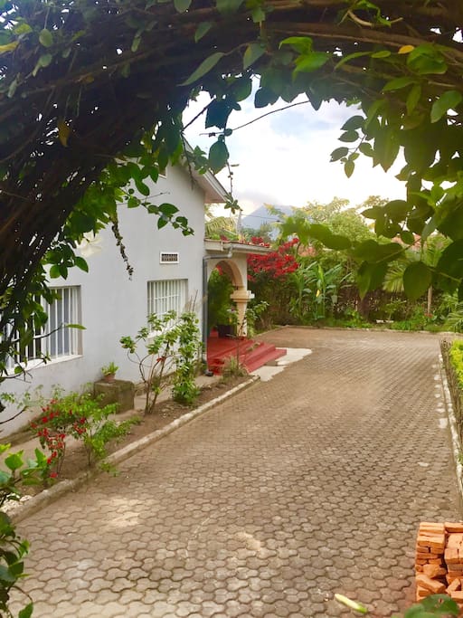 La maison vue du jardin et le volcan au fond.