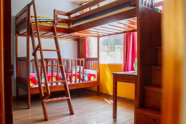 spavaća soba na drugom katu s krevetom na kat s 3 kreveta i pogledom na košarkaško igralište