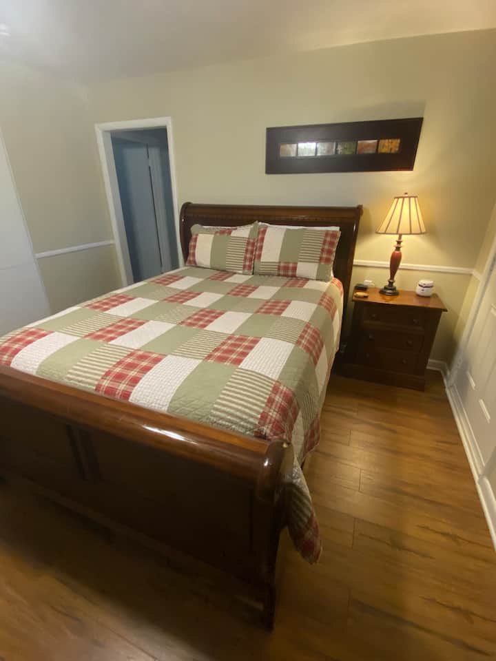 150-179 cm széles ágy a hálószobában. Hangtechnika töltővel az ágy mellett a telefonokhoz.