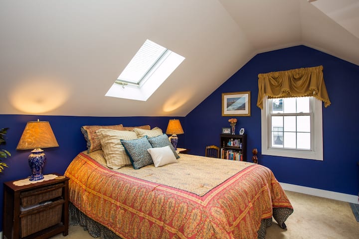 Chumba cha kulala cha ghorofa ya pili kilicho na kitanda cha ukubwa wa malkia na kiyoyozi cha dirisha.