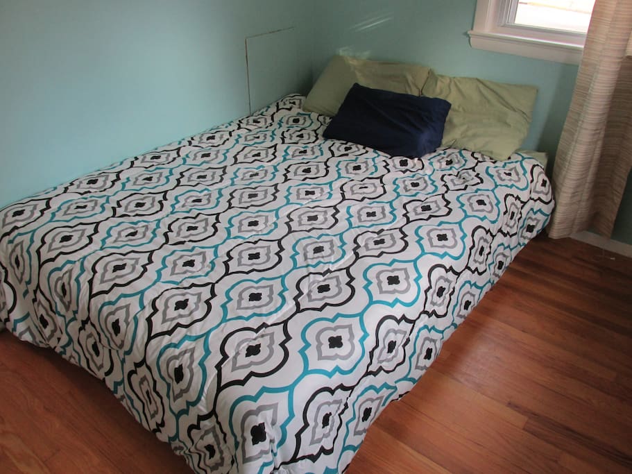 Queen-sized bed with linens and blankets provided.