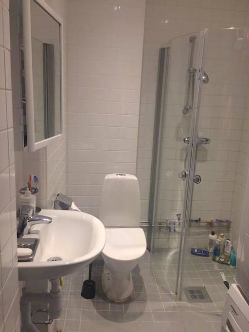 Delad toalett med tvättmaskin och torktumlare