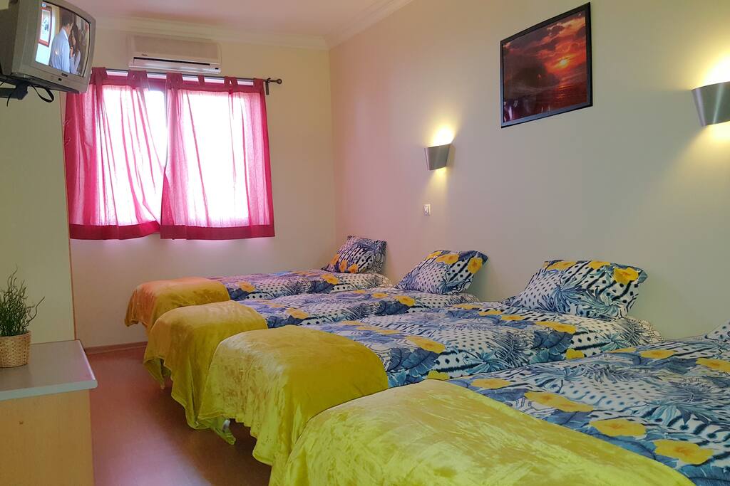 quarto com 4 camas individuais e TV cabo