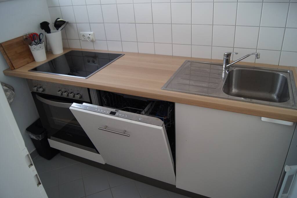 Küche mit Elektroherd, Cerankochfeld, Spülmaschine und Kühlschrank